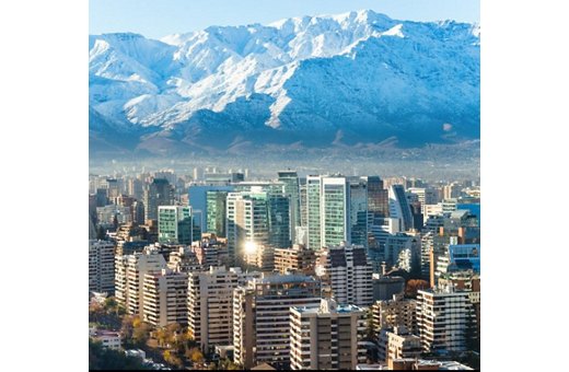 Cityscape of Santiago, Chile with modern buildings in the foreground and the snow-capped Andes mountains in the background.